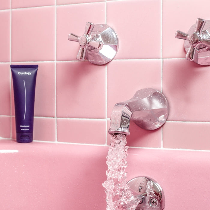 a pink bathtub with a faucet and soap dispenser