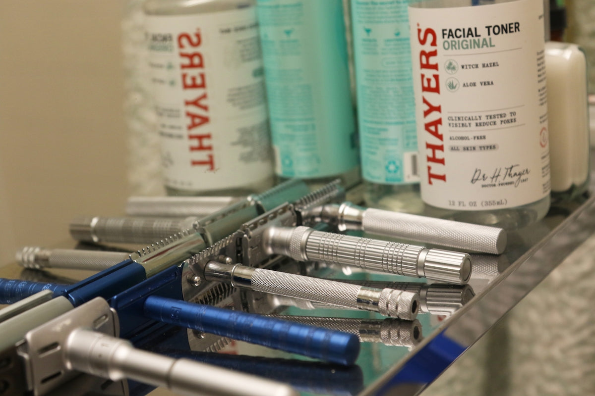 Collection of vintage safety razors and facial toner bottles.